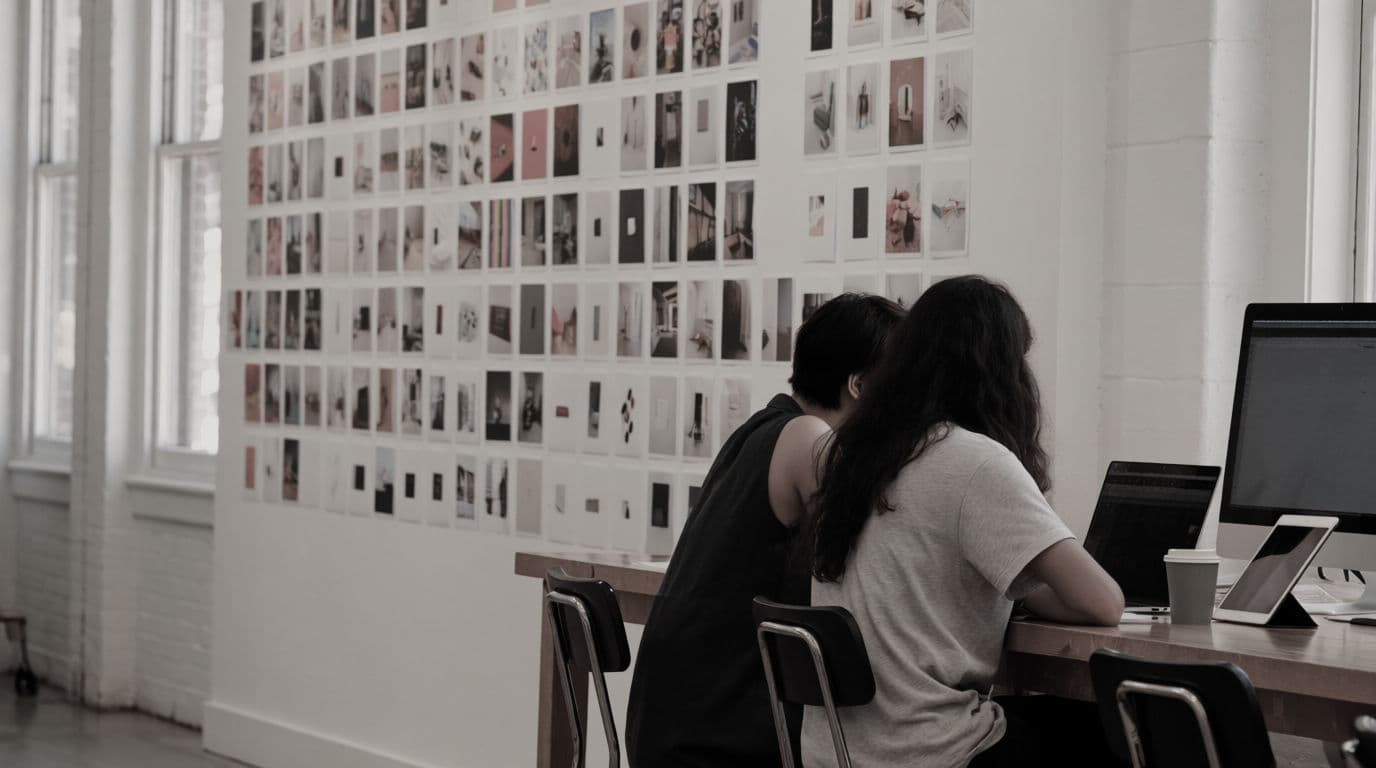 A creative agency team reviewing a wall of client work