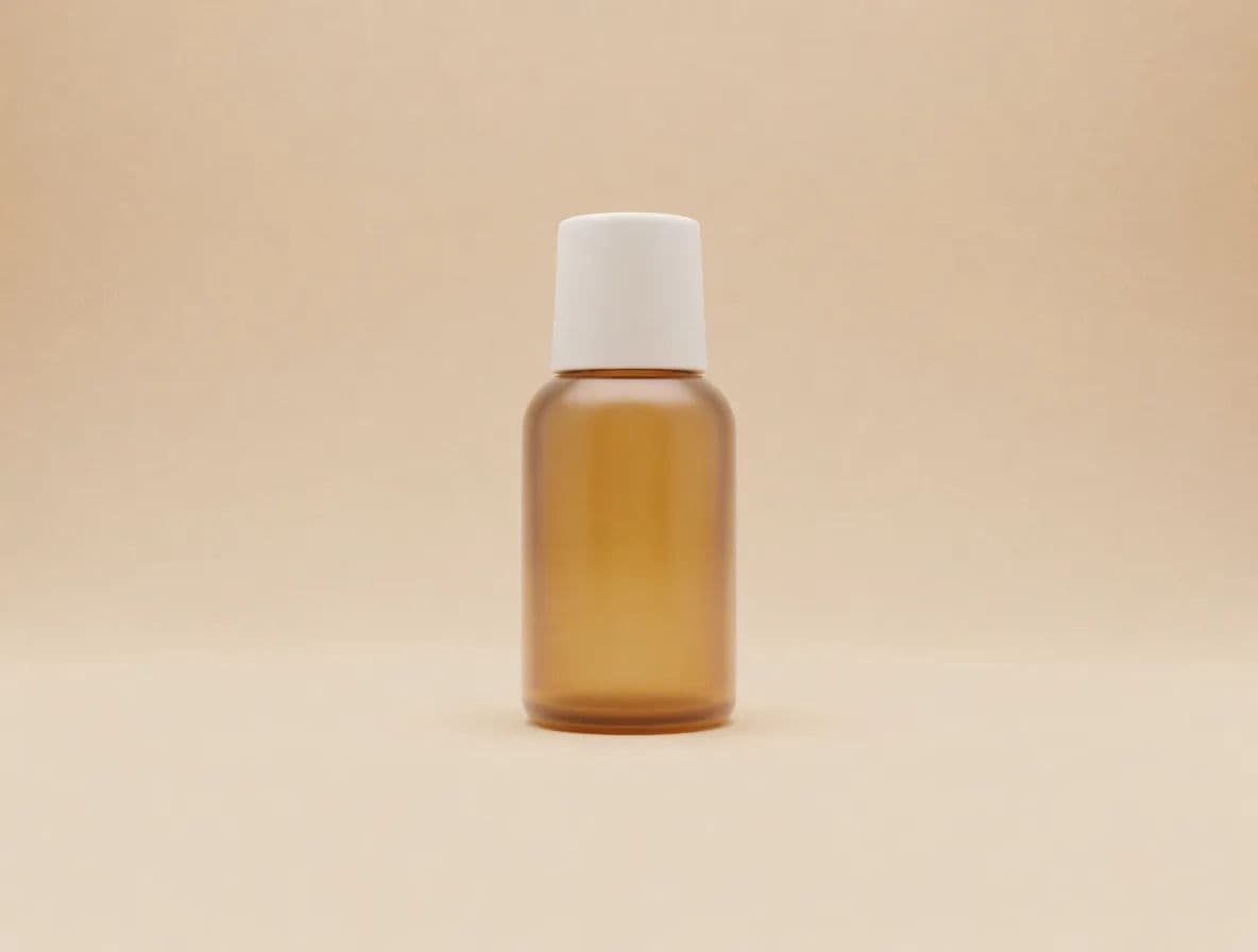 A single amber skincare bottle on a matching beige background