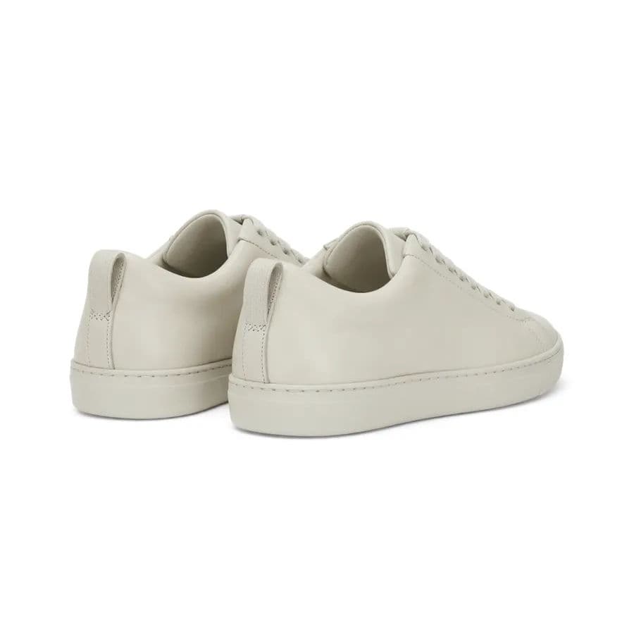The same white sneakers on a pure white background, heel-on view