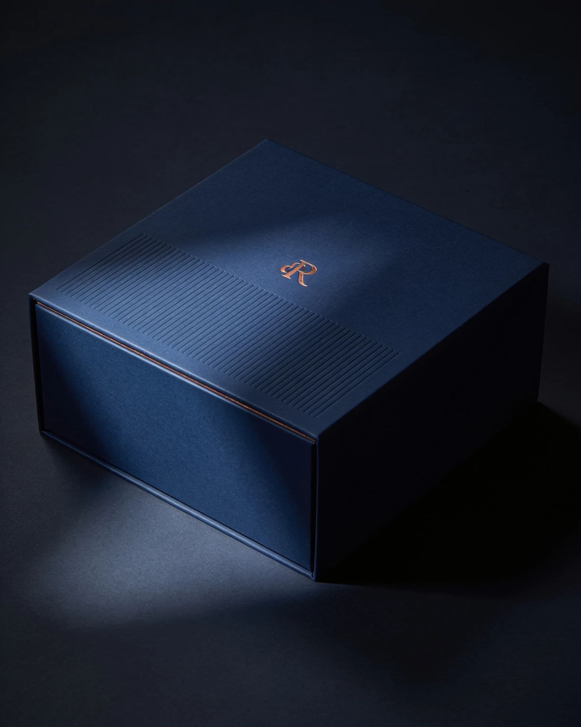 Luxury box with foil blocking and blind emboss under raking light, generated with Seedream 4.5