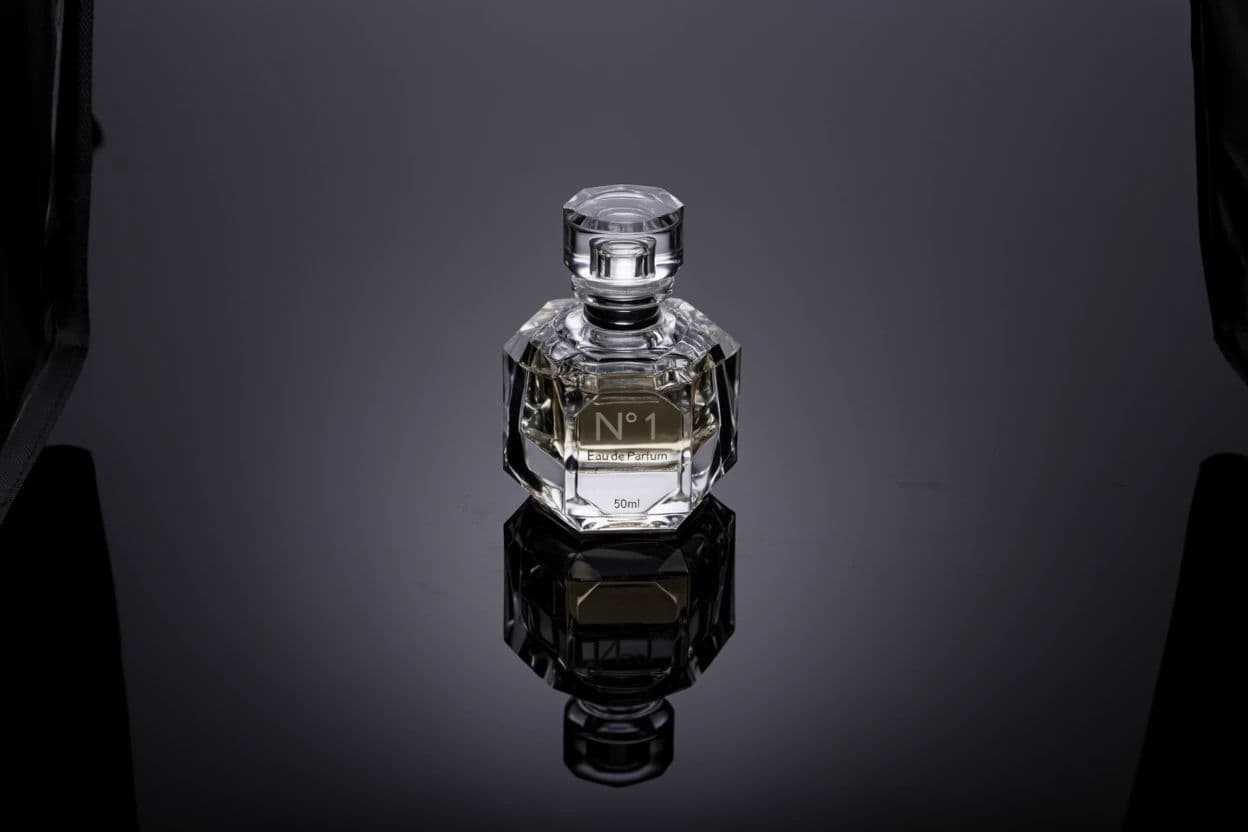 Black acrylic surface giving a perfume bottle a controlled mirror reflection, generated with Krea 2 Large