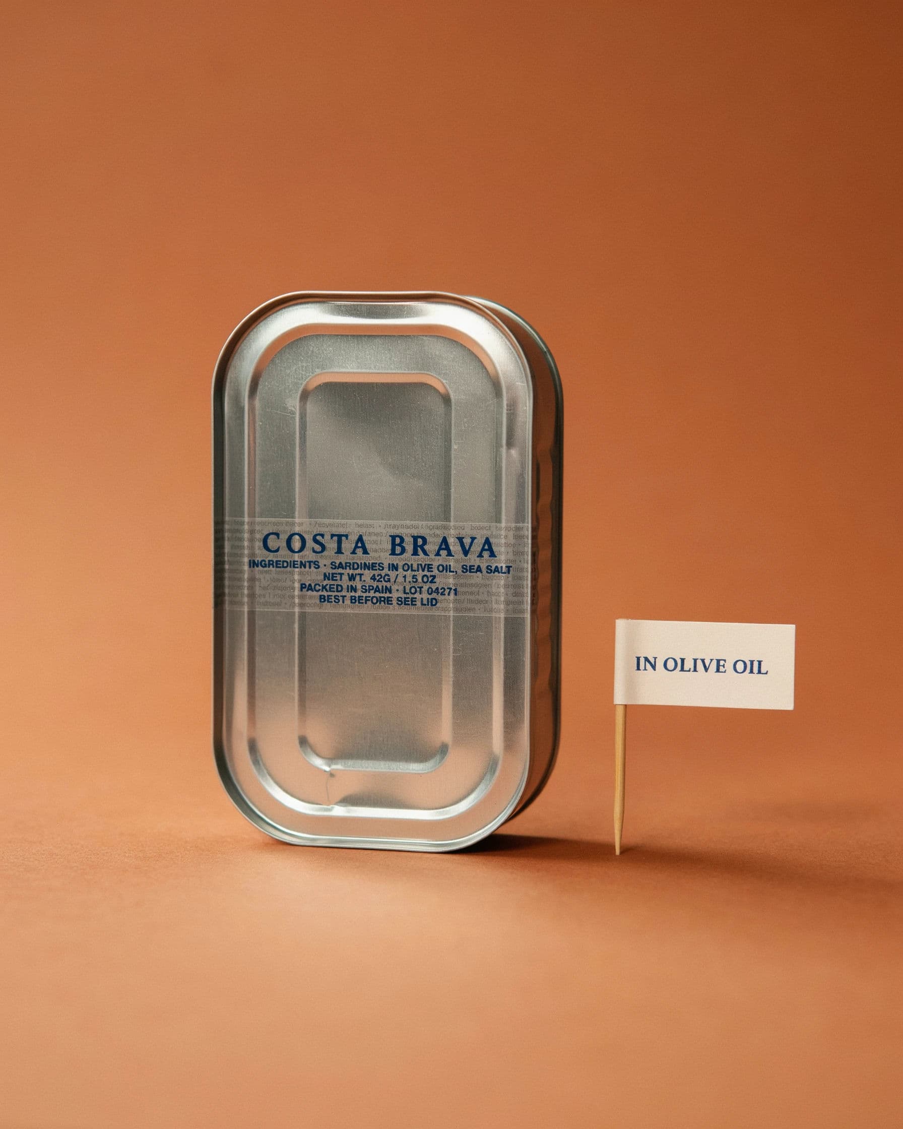 Packshot of a tinned fish product on seamless paper with a claim flag beside it, generated with Ideogram 4.0