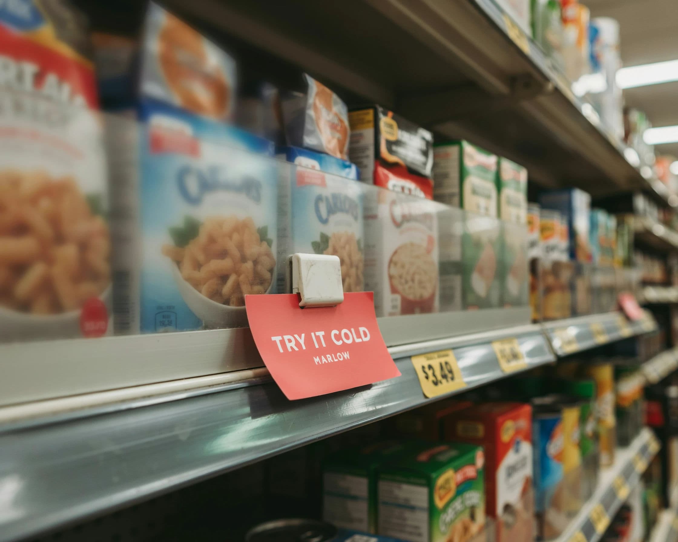 Retail shelf talker in situ on a supermarket shelf edge, generated with Ideogram 4.0