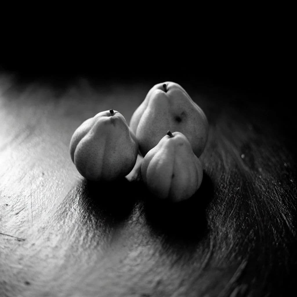 Black and white still life of three pears on a dark table lit from one side, generated with Krea 2 Medium