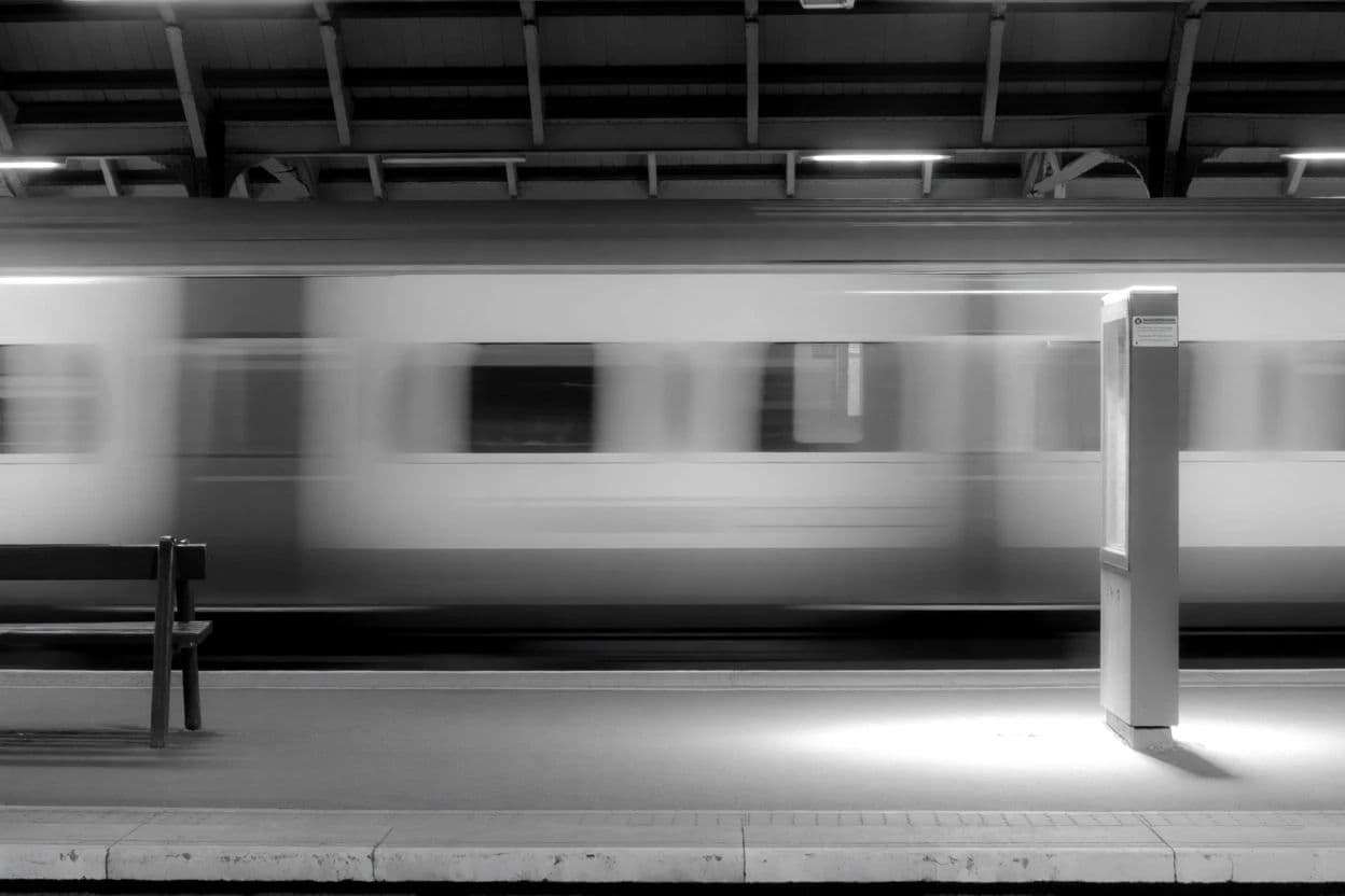Black and white photograph of a moving train with the platform sharp and the carriages blurred, generated with Krea 2 Medium