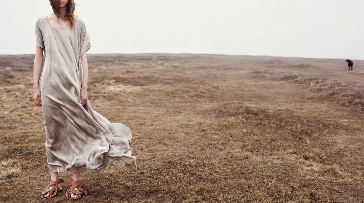 Wide fashion spread with the model placed far left and a large empty landscape to the right, generated with Krea 2 Large
