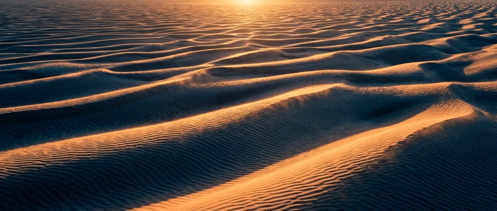 Wide panoramic desert photograph of dune crests picked out by low side light with deep shadowed troughs, generated with Nano Banana 2