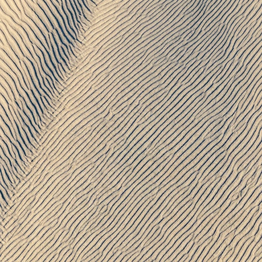 Aerial photograph looking down at wind ripples in a dune trough forming a repeating pattern, generated with Nano Banana 2