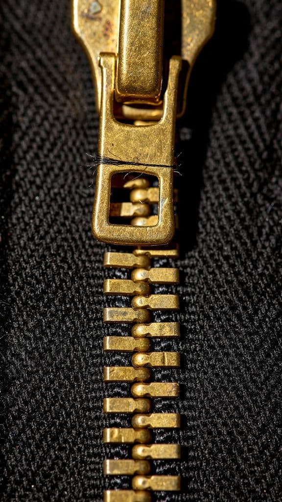 Vertical macro photograph of a metal zip at the exact point where the teeth interlock, generated with Flux 2 Pro