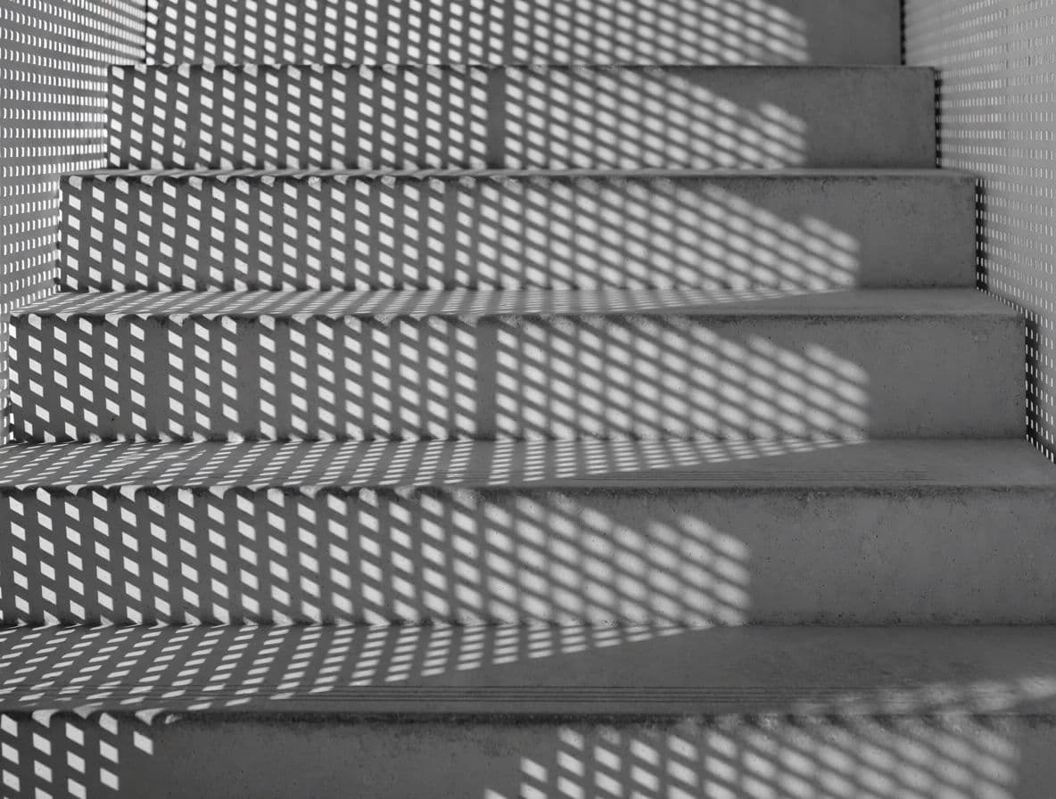 Photograph of a perforated screen throwing a grid of small shadows onto a stair flight, generated with Krea 2 Medium