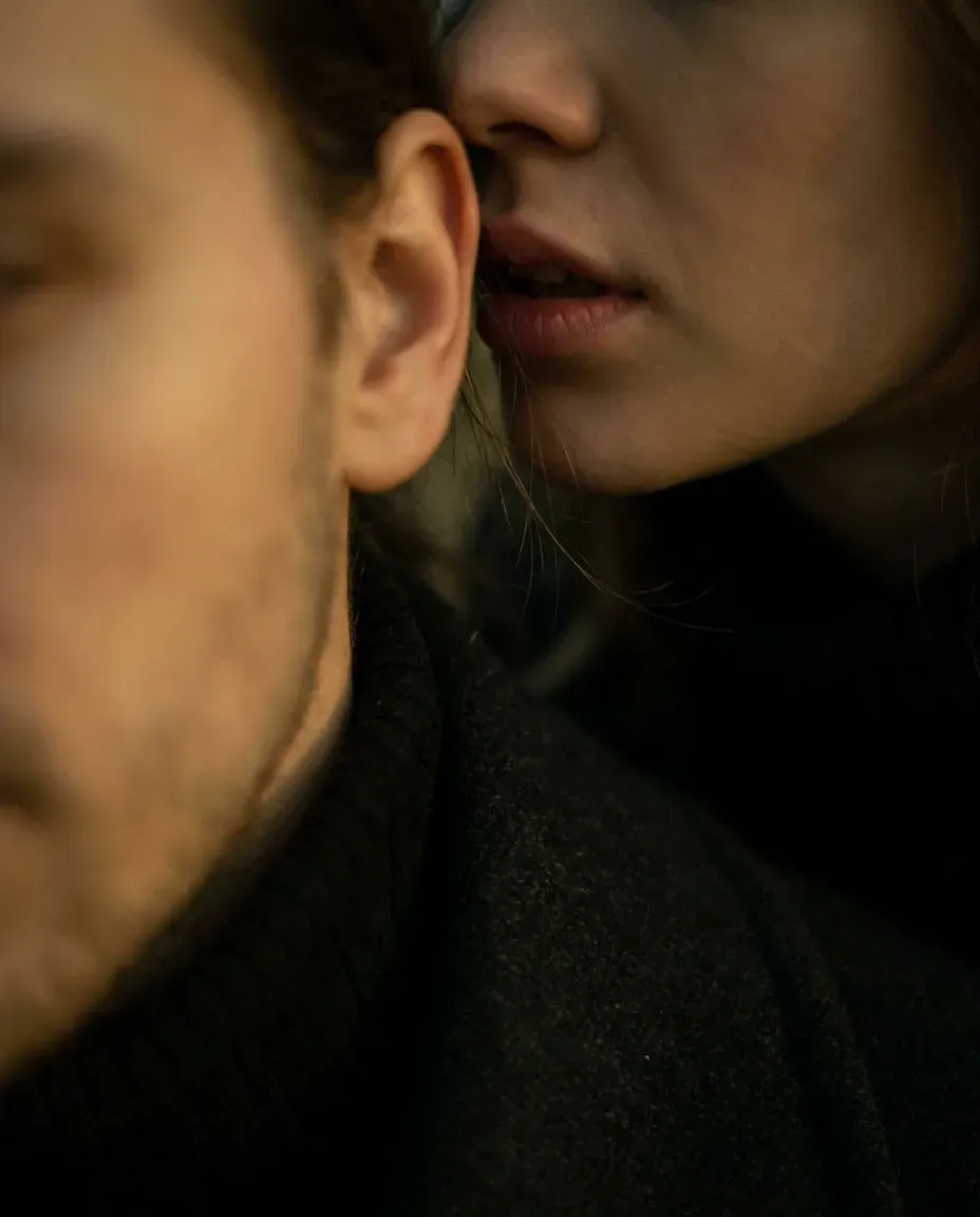 Vertical intimate whisper close-up of one person leaning in to murmur to another, generated with Morphic