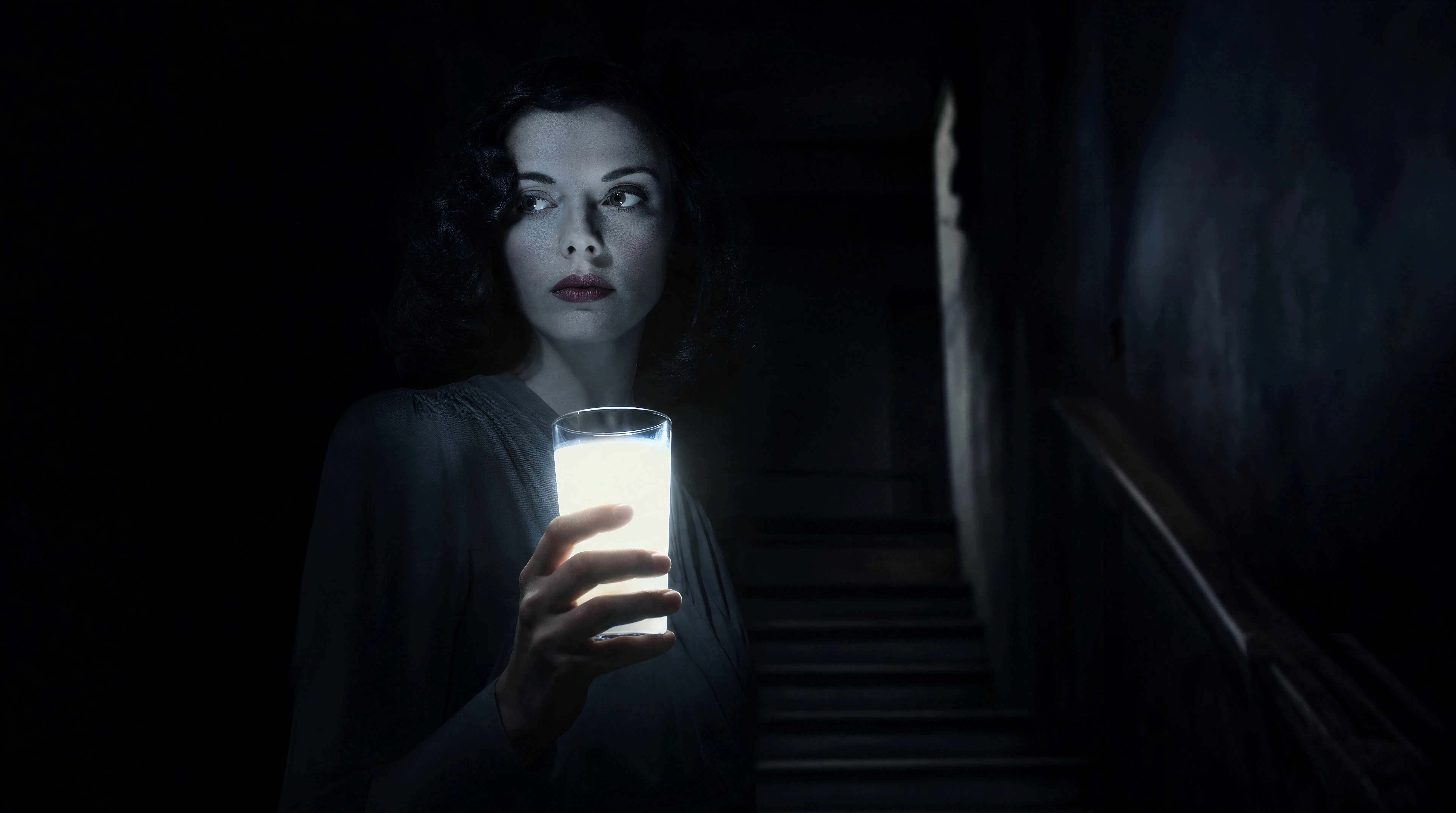 A single glass of milk on a dark stair