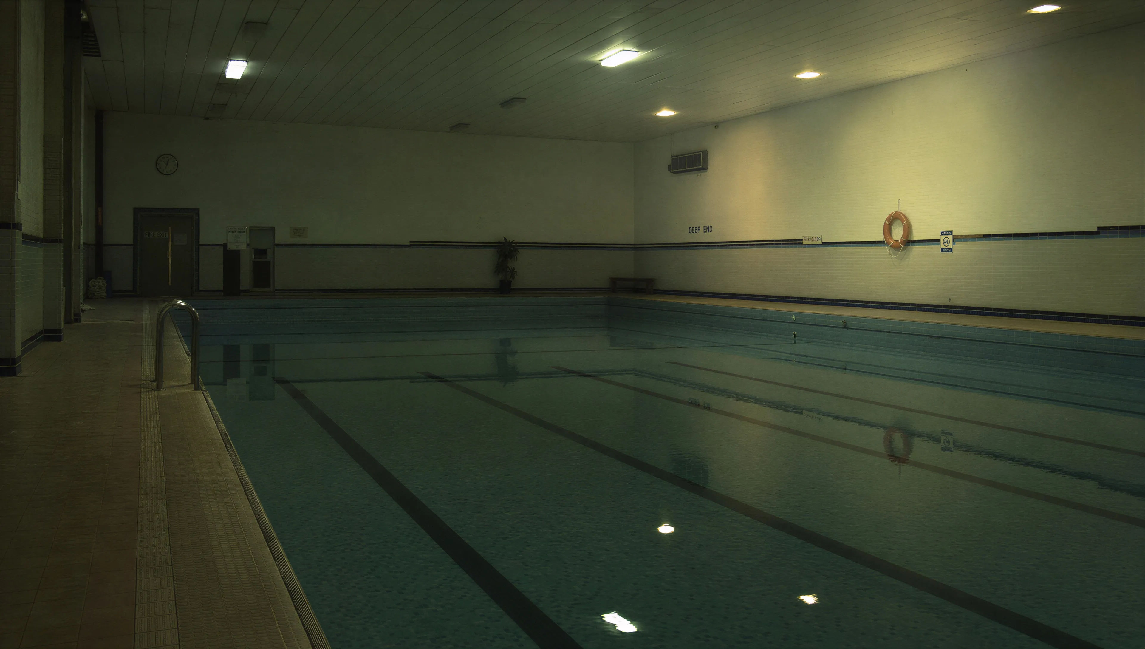 Piscina coberta vazia, com as luzes acesas